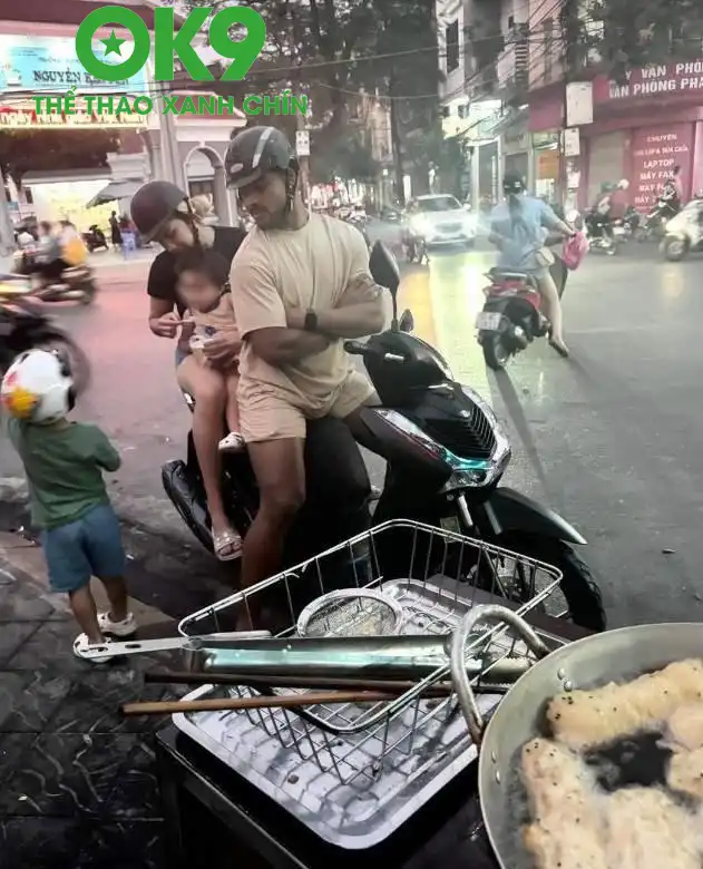 Xuân Son cùng vợ con đi mua bánh chuối chiên ở đường phố Nam Định (Ảnh: Cắt từ video)